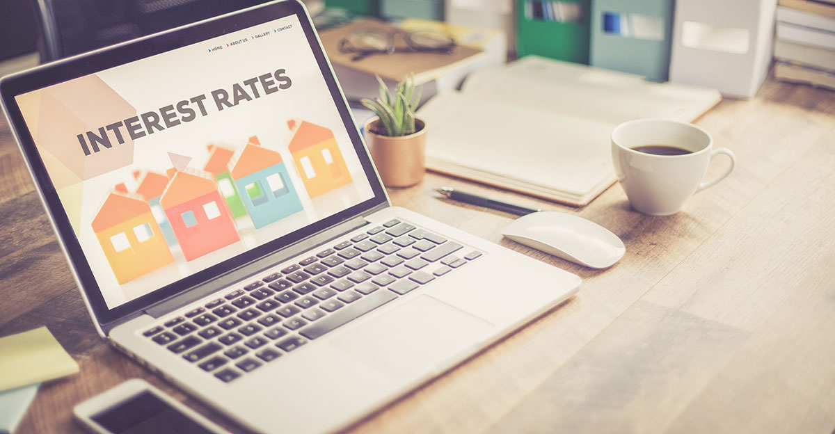 Laptop on a desk with interest rates graphic